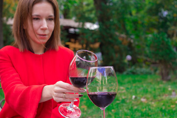 Girl in a red coat with a glasses of red wine