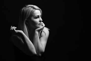 Fototapeta premium Close-up portrait of beautiful model with long blond hair on black background