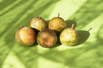 A few pears on a green background with sun highlights and shadows . A place for a space mine. Horizontal orientation
