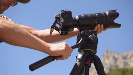 Nature Photographer Preparing Photo Equipment. Digital Camera with Telephoto Lens on a Tripod.