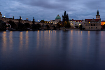 Fototapeta premium Charles Bridge. monument from 1402 in the center of prague on the flowing river vltava in the czech republic in the early evening after sunset and cloudy sky