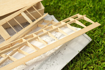 Details for building a glider model, part of the wing and instructions on the green grass