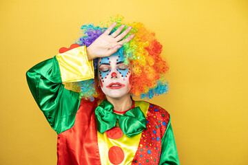 Clown standing over yellow insolated yellow background Touching forehead for illness and fever, flu and cold, virus sick