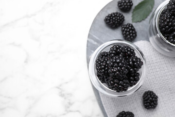 Fototapeta na wymiar Fresh ripe blackberries on white marble table, flat lay. Space for text