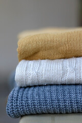 Stack of cozy sweaters. Selective focus.