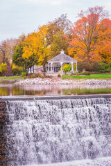 Fototapeta na wymiar Waterfall Surrounded by Fall Foliage and a Pavilion