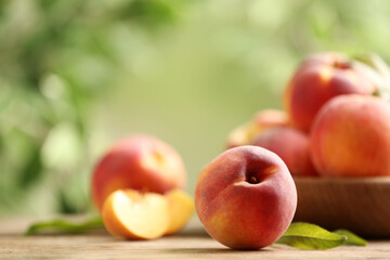 Fresh sweet peaches on wooden table outdoors