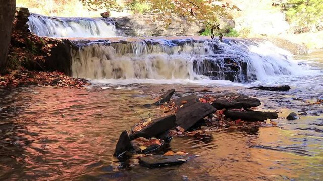 Peak fall foliage surrounds beautiful cascading upper side Shohola Falls on an Autumn morning in the Pennsylvania Poconos
