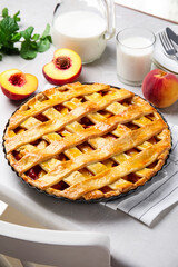 Delicious peach pie and fresh fruits on light kitchen table