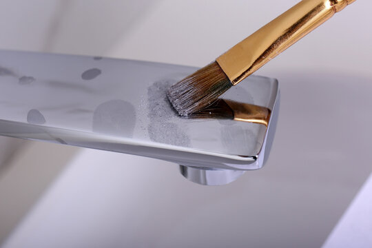 Using Brush And Powder To Reveal Fingerprints On Faucet Indoors, Closeup