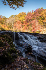 Peak fall foliage surrounds beautiful cascading upper side Shohola Falls on an Autumn morning in the Pennsylvania Poconos