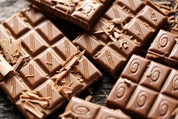Broken chocolate bars on dark background