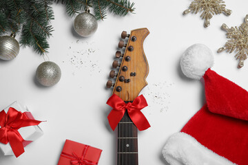 Flat lay composition with guitar and Santa hat on white background. Christmas music