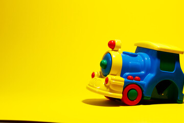 Colorful train is broken yellow background.Copy space.Children's toy