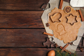 Dough, different cutters and ingredients for Christmas cookies on wooden table, flat lay. Space for text