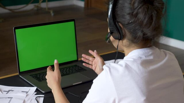 Close-Up Of A Young Indian Woman Communicating With A Client Using A Laptop With A Green Screen Working Online Conference Call, Training With People, Using A Computer. Bright Room In The House Chair