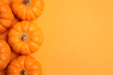 Fresh ripe pumpkins on orange background, flat lay. Space for text