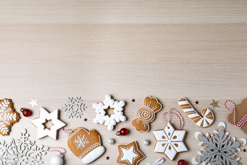 Decorated Christmas cookies on wooden table, flat lay. Space for text