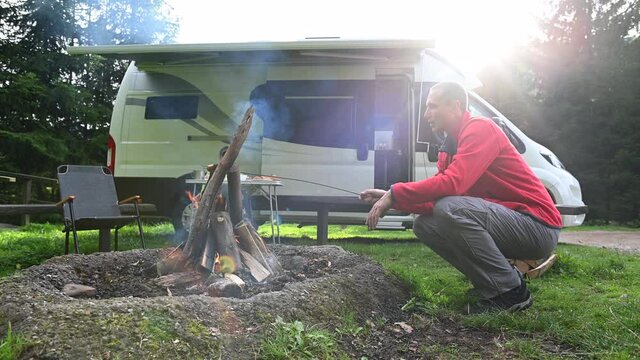 Men Baking Polish Sausage on Campfire