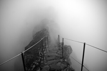 Path to the Pico Ruivo and Pico do Arieiro mountain peaks in a fog in Madeira, Portugal. A mystic path, road to nowhere