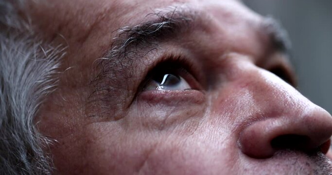 Senior man eyes lifting head to sky with hope and faith
