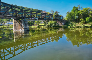 Fototapeta na wymiar Metal and Concrete Walking Bridge Over Danube River with Reflection