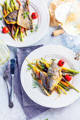  sea fish with rainbow carrot and wine     glasses on bright table. gourmet dissh