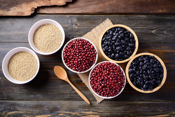 Black kidney beans, azuki beans and quinoa seeds in a bowl on wooden background, Top view