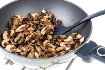 Sliced champignons fried in pan isolated on white background.