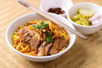 Northern Thai food (Khao Soi), Spicy curry noodles soup with beef eating with pickled mustard, shallot, lime and ground chili fried in oil