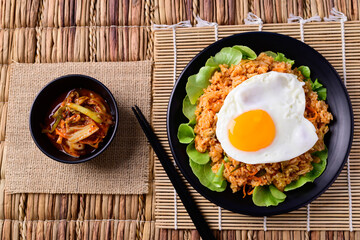 Korean food, Kimchi fried rice with fried egg on top and fresh kimchi cabbage, Top view