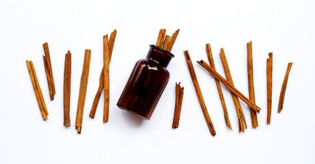 Cinnamon sticks with medicine bottle on white