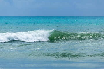 wave on the turquoise sea, amid storm clouds