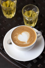 Cup of coffee with latte art on black table