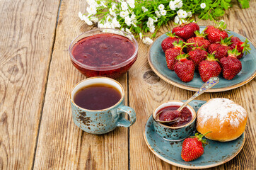 Ripe red sweet strawberry jam, fresh berries on wooden table