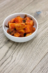 Korean traditional radish kimchi (kkakdugi) on wooden table