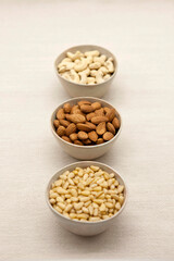 Various nuts (Pine nuts, almonds and cashew nuts) in a line.