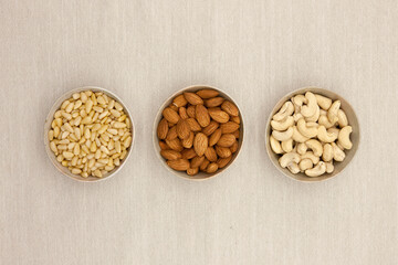 Various nuts (Pine nuts, almonds and cashew nuts) in a line.