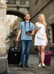 portrait of happy couple tourists visiting town on summer day