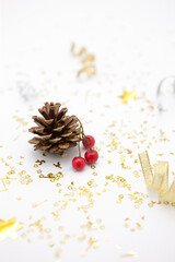 Pine cone and Red berries with gold glitters on white background.