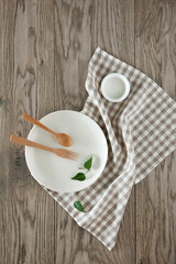 Plates and kitchen clothes on wooden table.