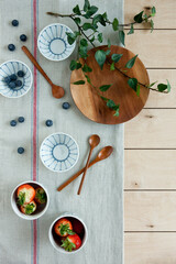 Blueberries, strawberries and wooden utensils on table.