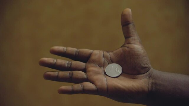 two indian rupees coin in hand feast opeing hand reviling coin.