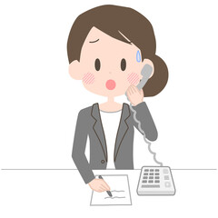 困った表情で電話応対をするビジネスウーマン