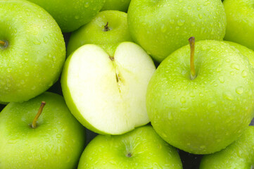 Green apples with water drops as background