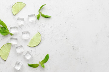 Ice cubes, mint and lime on light background