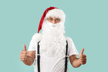 Fototapeta na wymiar Santa Claus showing thumb-up on color background. Christmas vacation