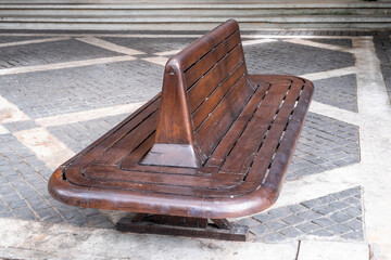 Vintage style old wooden bench on the pavement with cobblestone floor.
