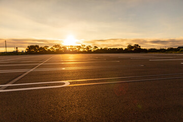 Fototapeta premium 無人の駐車場 朝日 希望 新しい一日のイメージ
