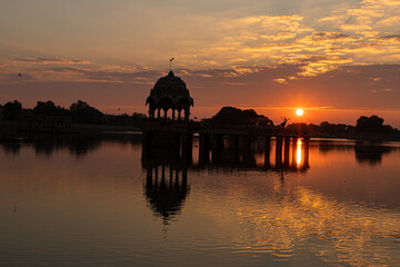 Fototapeta premium Ancient architecture ruins at Gadi Sagar (Gadisar) lake Jaisalmer, Rajasthan at sunrise.